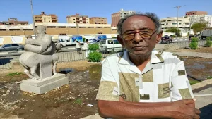 فنان تشكيلي يعلق على تمثال شخص يركب حصانًا بالمقلوب بأسوان